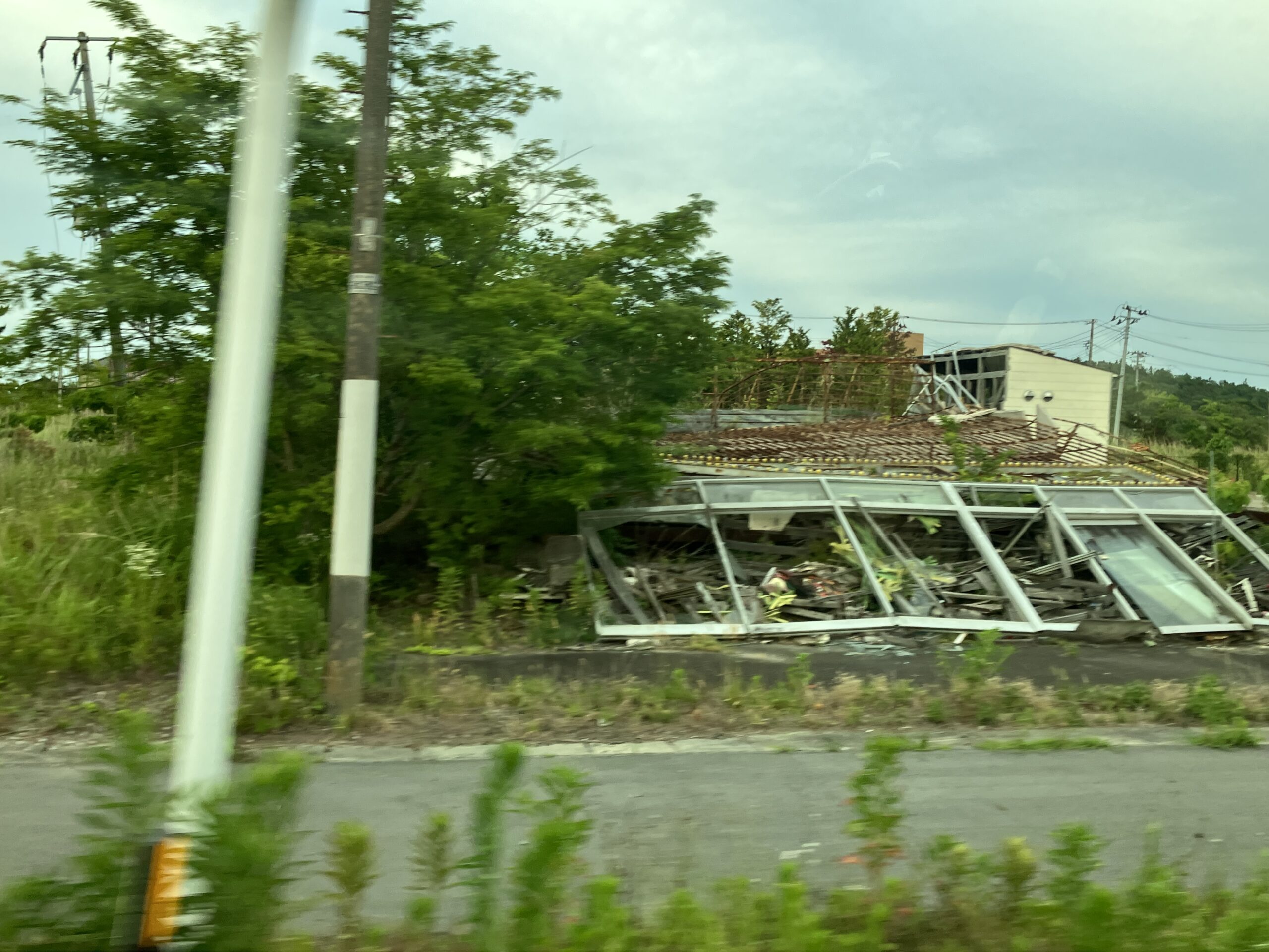 写真1: 双葉町から大熊町へと向かう国道六号線沿いの壊れた建物。私が初めて現地を訪れた2018年から、現在もなおこの状態で取り残されている。